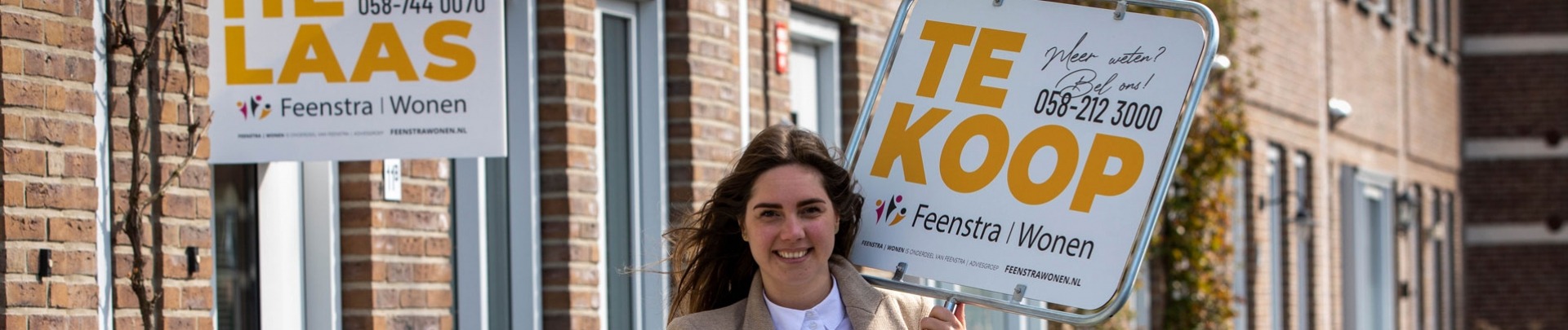 De makelaar van Feenstra Wonen loopt met een verkoopbord op je af